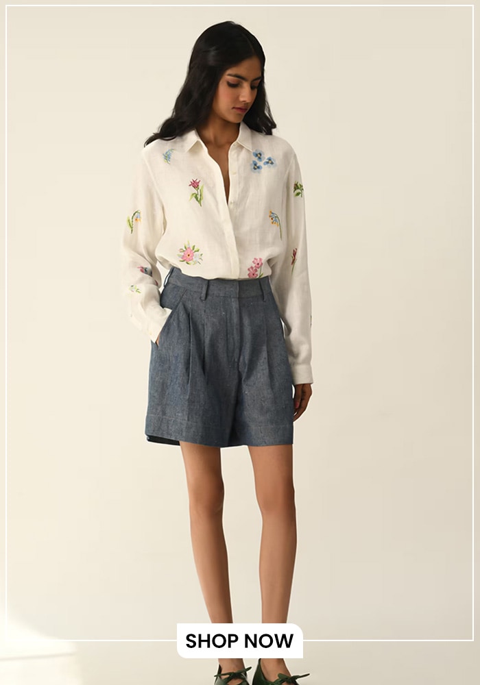 Model wearing denim pleated shorts with a white full sleeve shirt