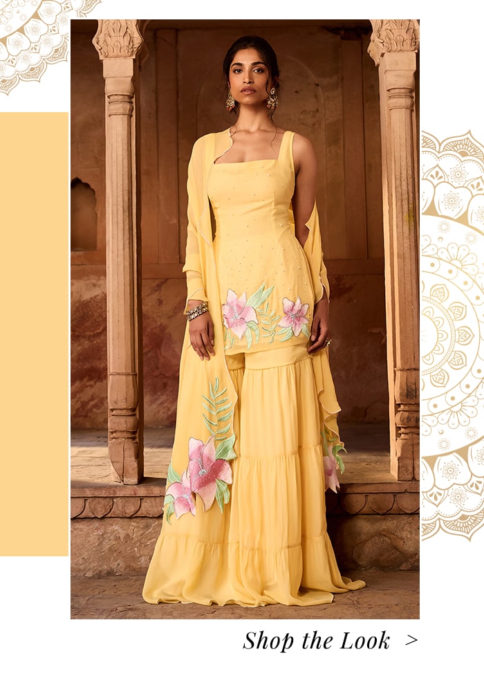 Model wearing a yellow short kurta paired with sharara pants and a dupatta