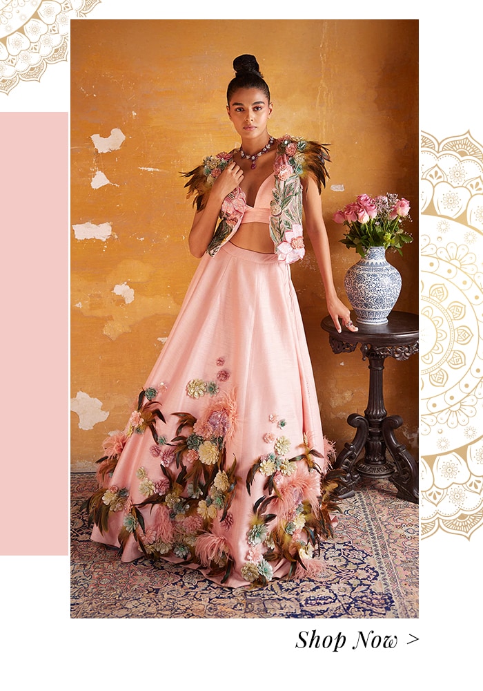 Model wearing a pink 3D embellished crop top and skirt set with a cropped cape jacket