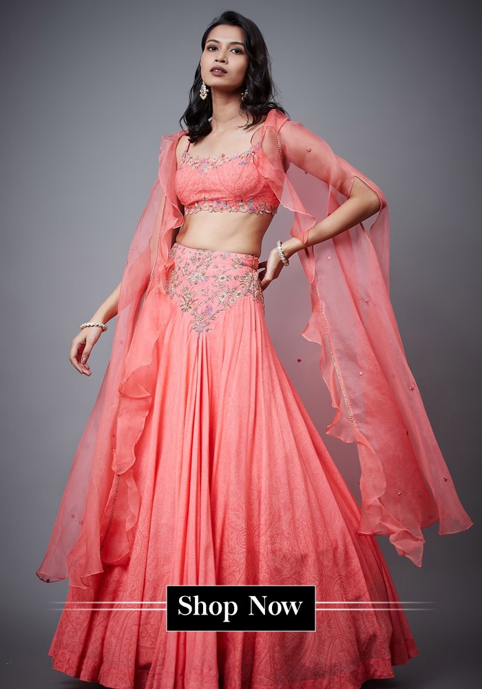 Model wearinga  coral cape lehenga
