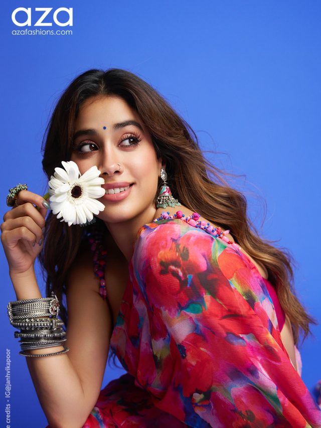 Janhvi in a floral printed chiffon saree holding a white flower