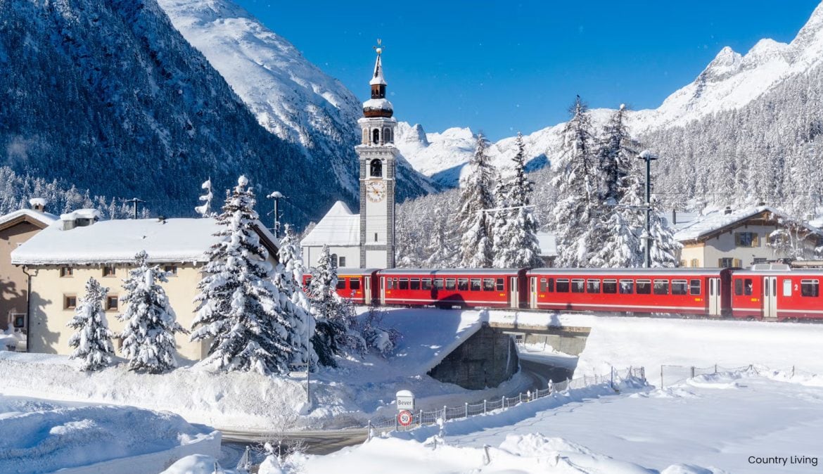 Train moving through snowy mountains in Switzerland