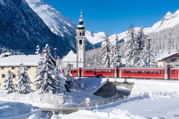 Train moving through snowy mountains in Switzerland