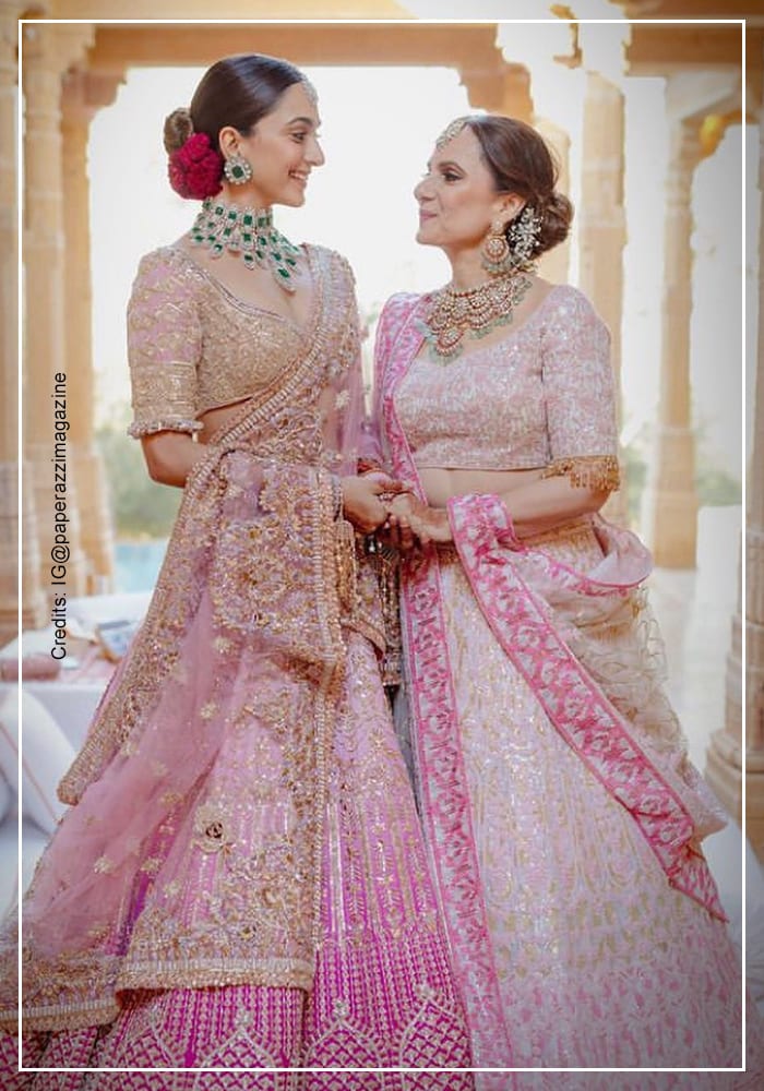 Kiara Advani in her pink wedding lehenga and polished bun with her mother