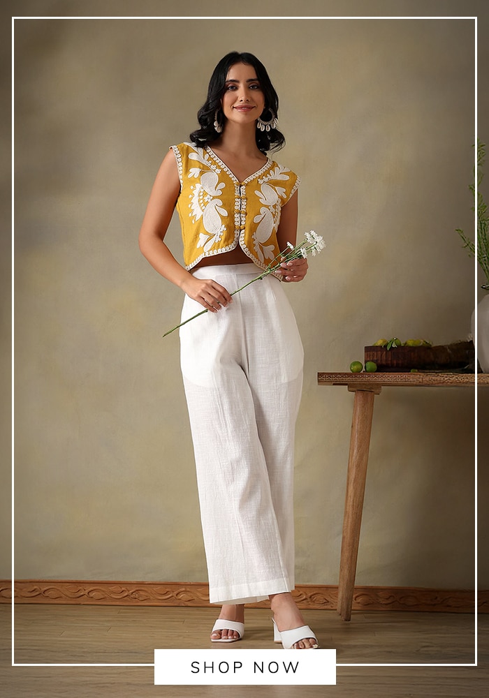 White flared pants and yellow embroidered sleeveless cotton jacket