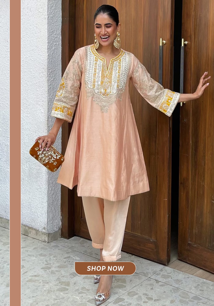 Peach embroidered choga salwar suit styled with statement earrings, perfect for festive daytime celebrations