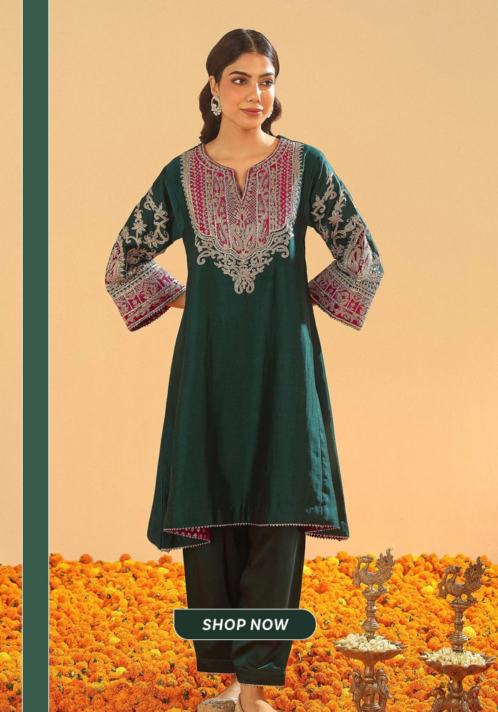 Model wearing an emerald green embroidered choga salwar suit styled for festive occasions, featuring intricate neckline and sleeve detailing