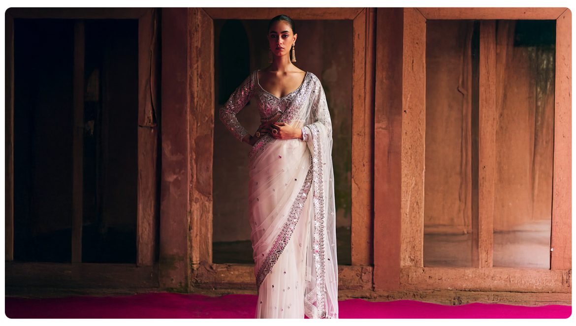 Model wearing a white embellished saree styled for Mahashivratri, reflecting minimal festive ethnic wear for women