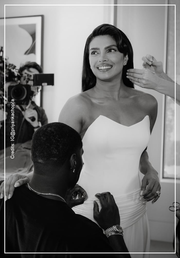 Priyanka Chopra Jonas smiling during final fitting of custom 
white Dior gown with styling team behind the scenes at Oscars 2026