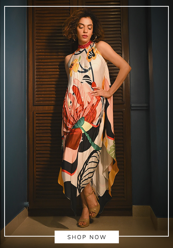 Woman wearing a multicolour botanical print halter maxi dress with an asymmetrical hem, styled for an elegant Mahjong party and luxury daytime gathering