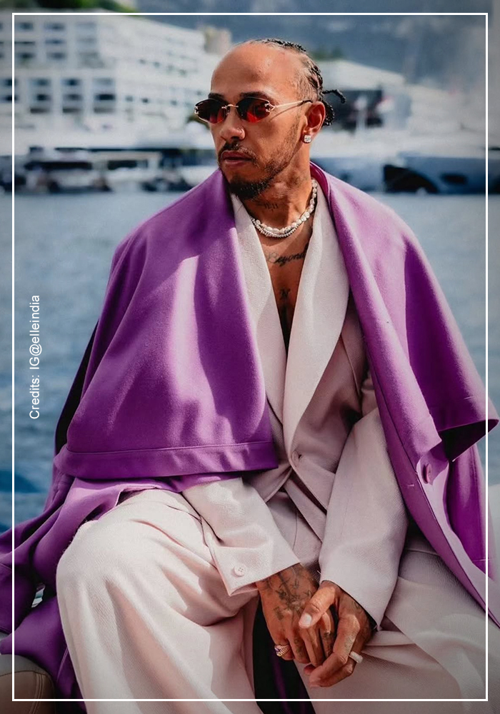 Lewis Hamilton wearing purpe overcoat and white shirt and trousers at Grand Prix 1