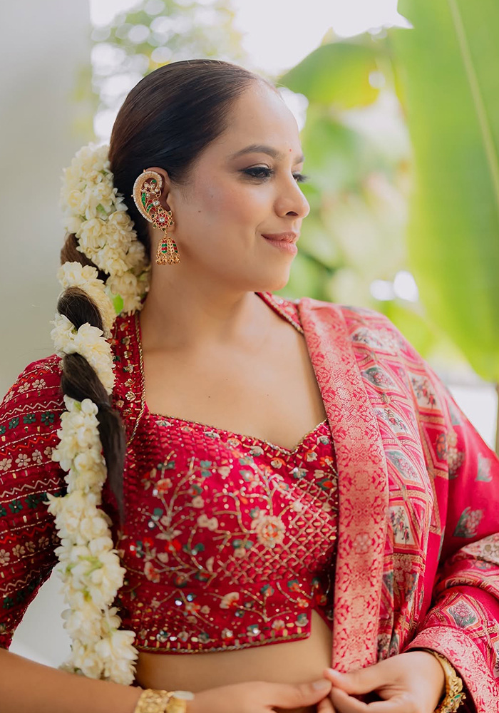 Abhinisha Jani Ashara wearing maroon lehenga and gajra