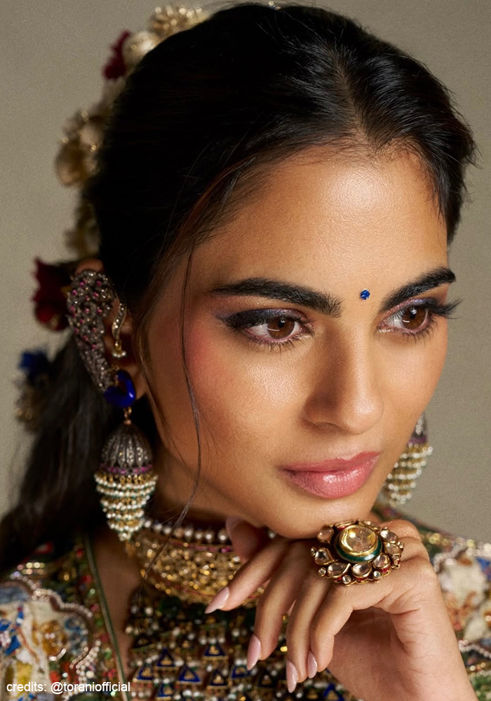 Isha Ambani wearing blue eyeshadow and pink lips with her Torani lehenga